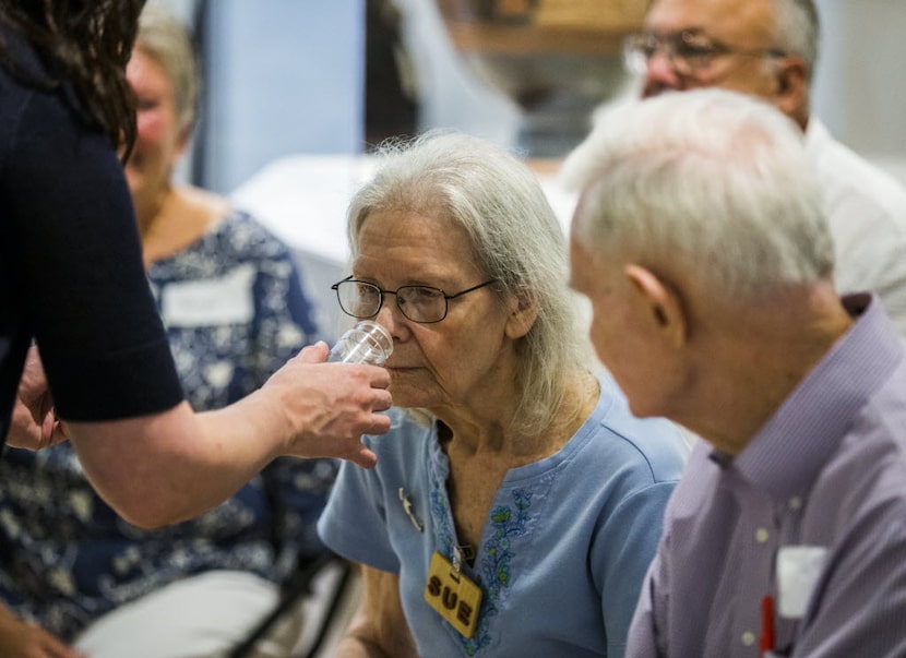 Sue Rath smells a sample scent of olive leaves as part of the Dallas Museum of Art's...