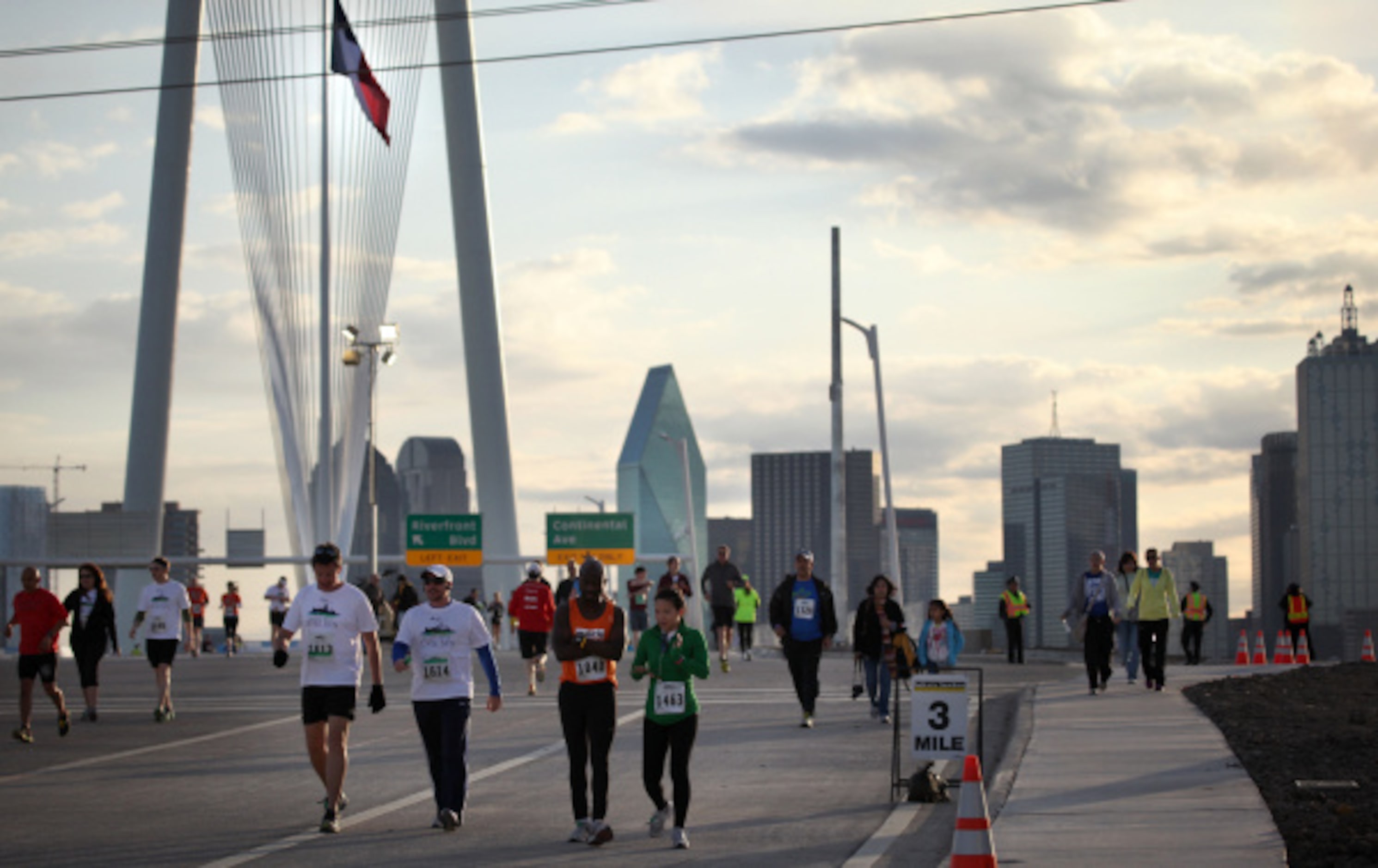 Participants walk over the Margaret Hunt Hill Bridge in Dallas, TX towards the  starting...