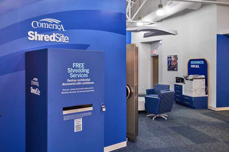 View of a bank lobby with a large locked box marked "Comerica Shredsite" in the foreground