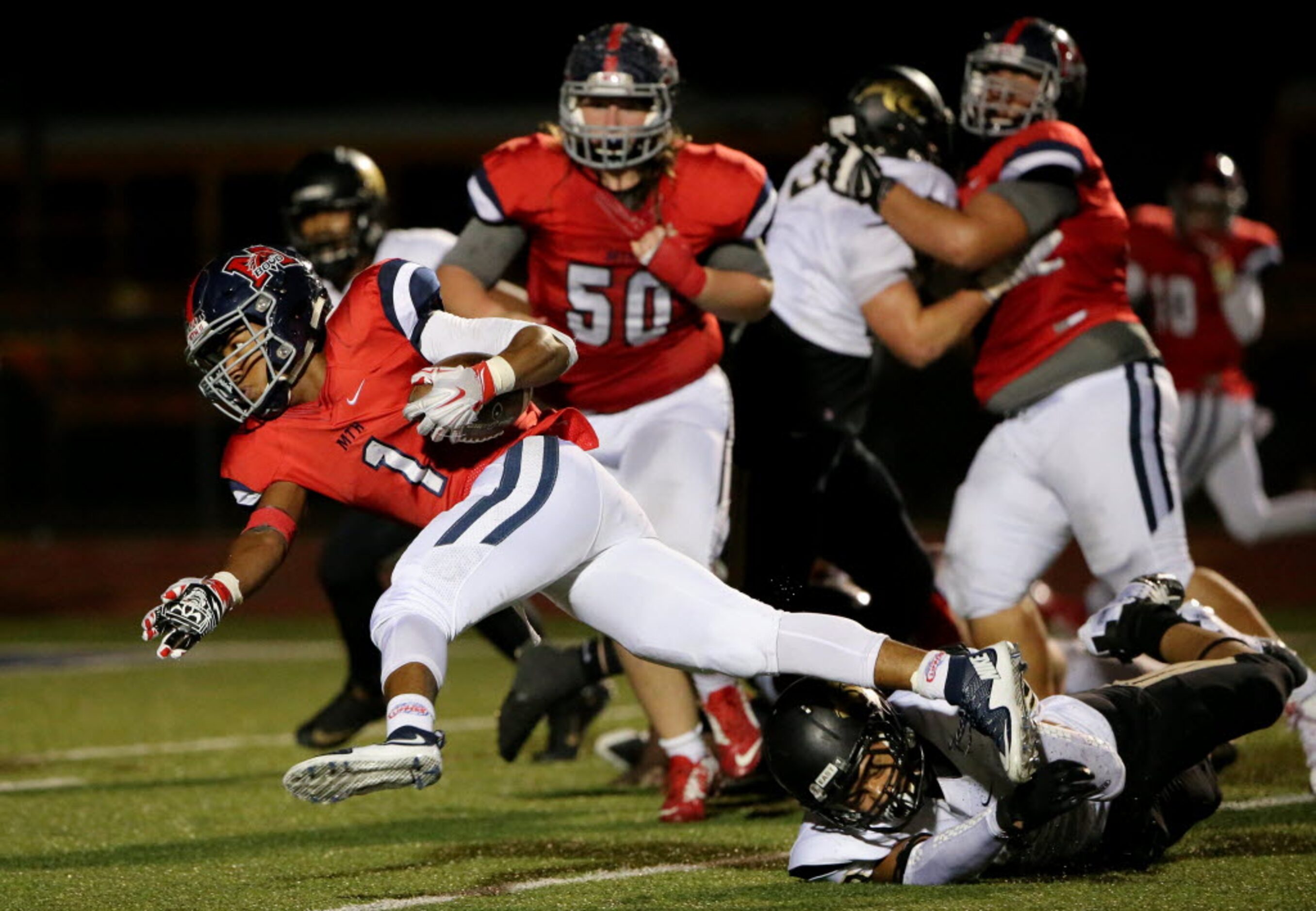 McKinney Boyd running back Kaeden Markham (1) is tripped up by Plano East linebacker Anthony...