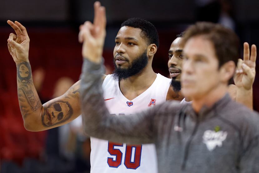 Southern Methodist Mustangs forward Marcus Weathers (50) and head coach Tim Jankovich listen...