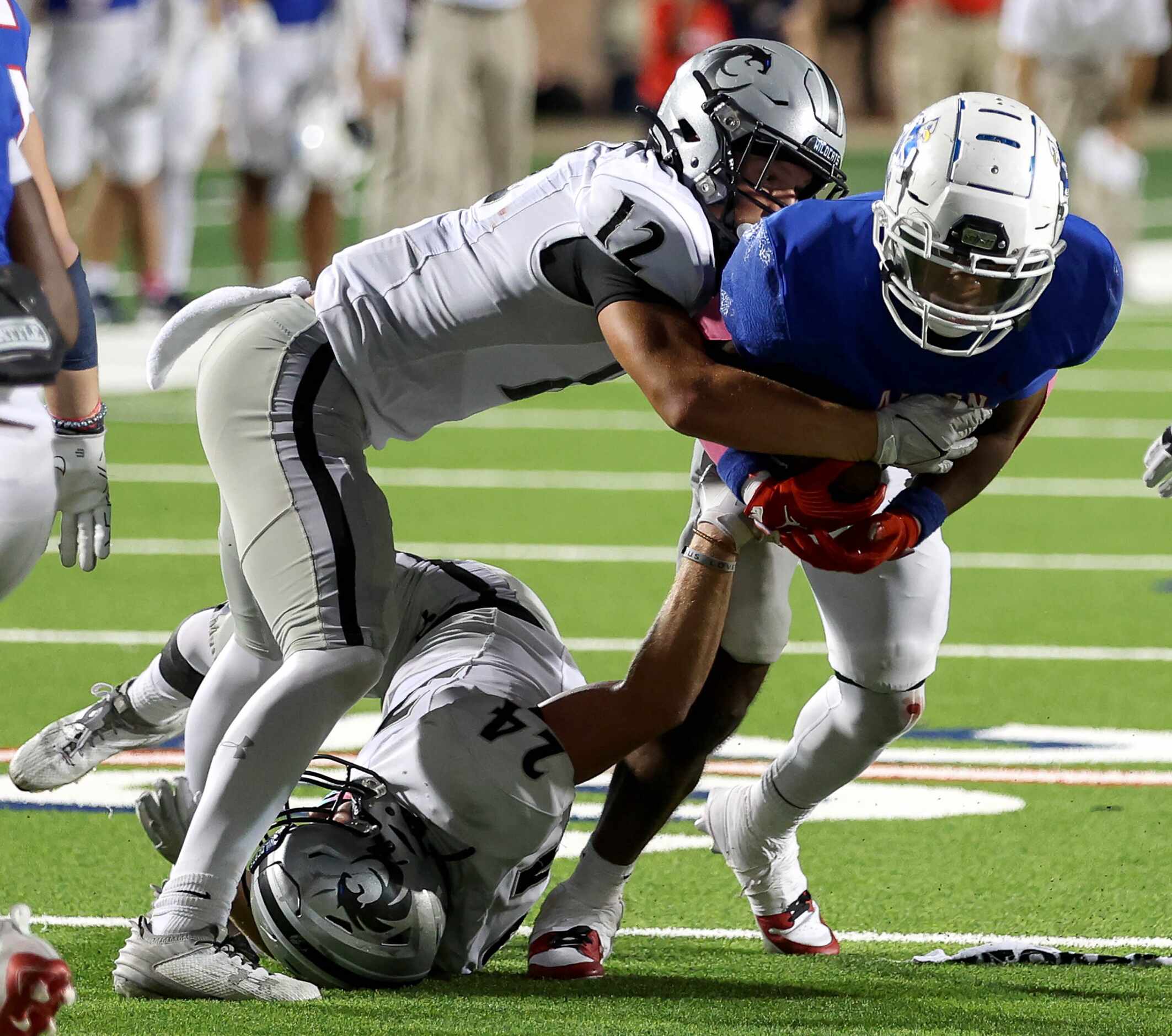 Allen running back Micah Ellis (right) gets stopped for no gain by Denton Guyer defensive...