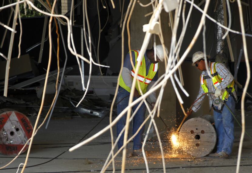 Workers prepare one of Methodist Dallas Medical Center’s buildings for demolition. A $108...