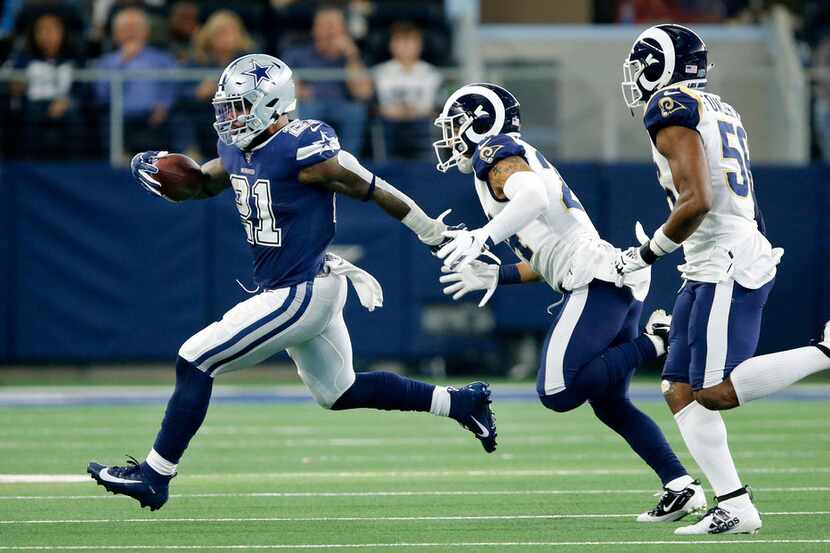 FILE - Cowboys running back Ezekiel Elliott (21) runs away from Rams safety Taylor Rapp (24)...