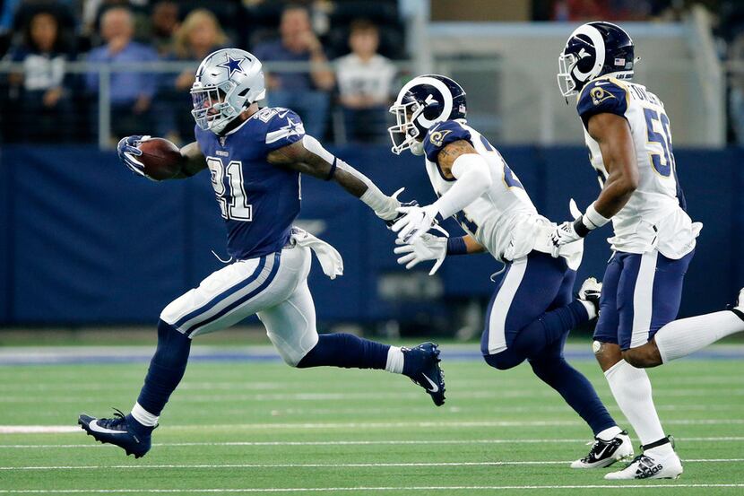 FILE - Cowboys running back Ezekiel Elliott (21) runs away from Rams safety Taylor Rapp (24)...
