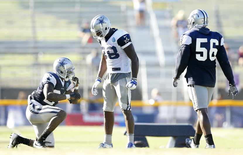 Dallas Cowboys wide receiver Dez Bryant (88) stands over cornerback Morris Claiborne (24)...