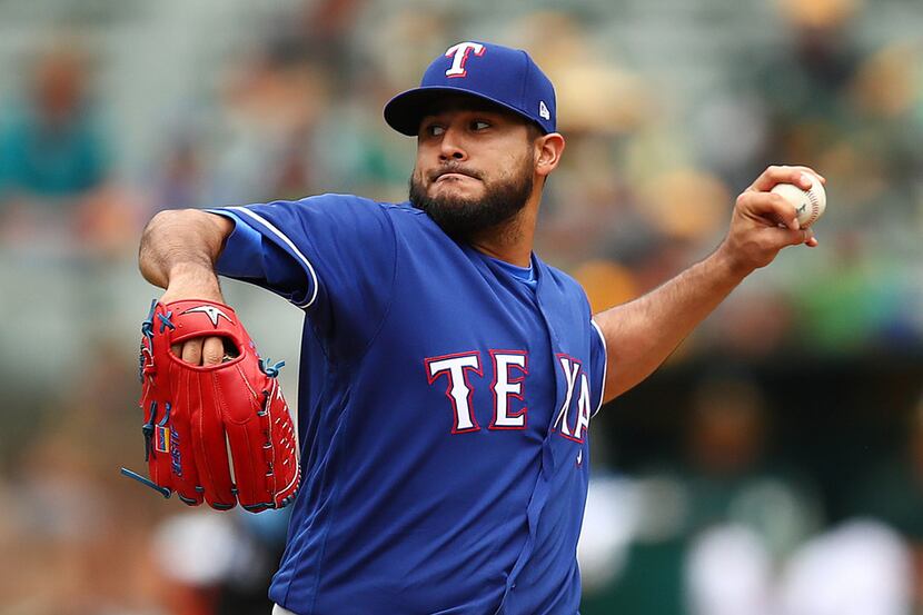 Texas Rangers pitcher Martin Perez works against the Oakland Athletics during the first...