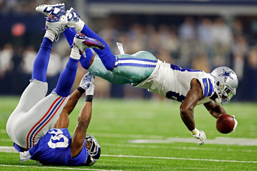 Dallas Cowboys wide receiver Dez Bryant (88) goes airborn as he's tackled by New York Giants...