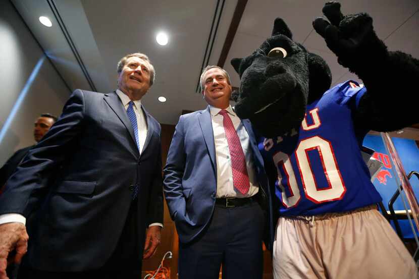 SMU president Gerald Turner (left) and SMU mascot Peruna (right) take photos with new...