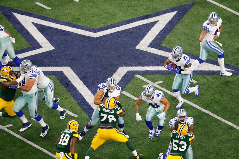 Dallas Cowboys quarterback Dak Prescott (4) hands the ball off to running back Ezekiel...