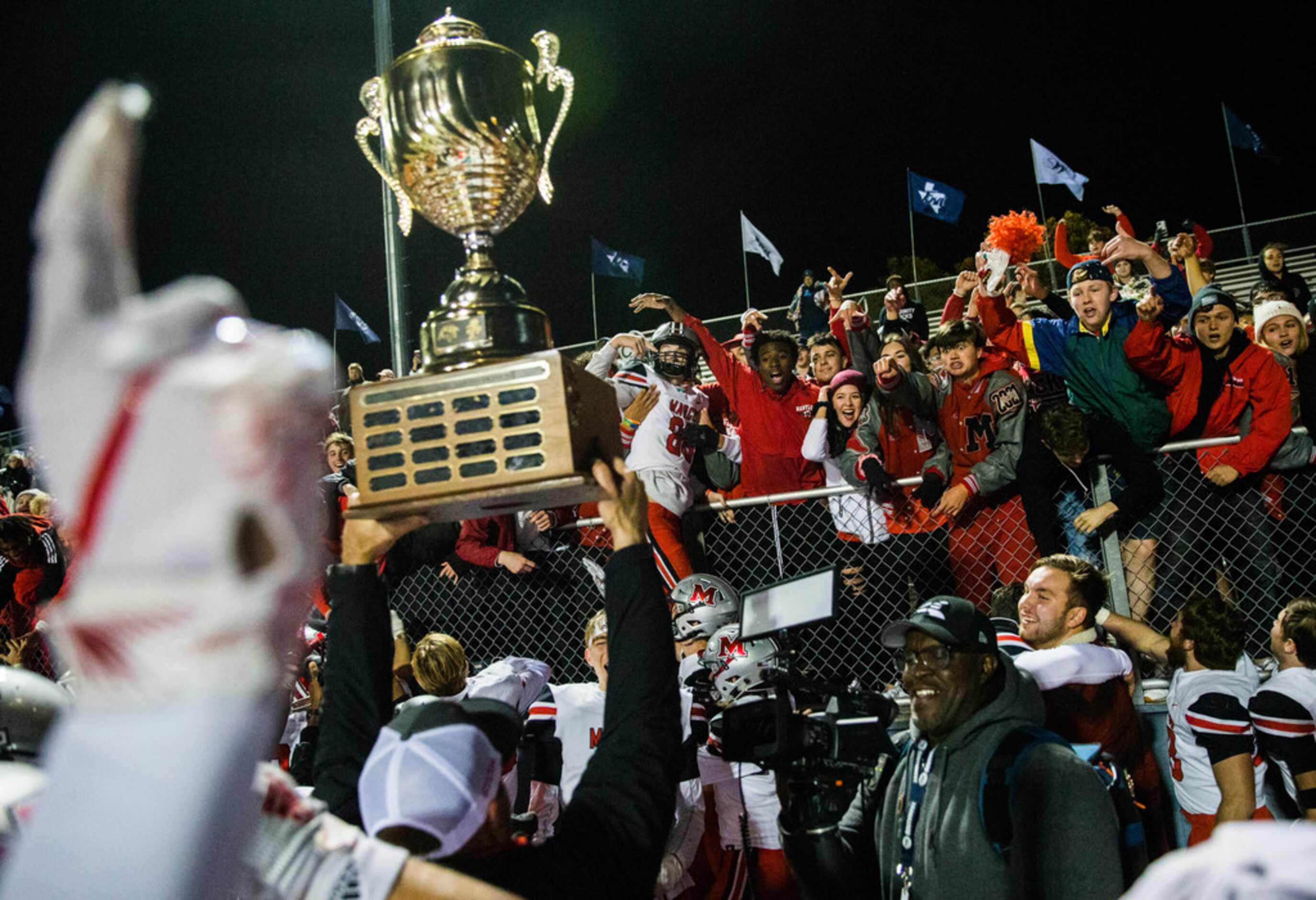 Flower Mound Marcus hoists the Mound Showdown trophy after a 34-31 win over Flower Mound on...
