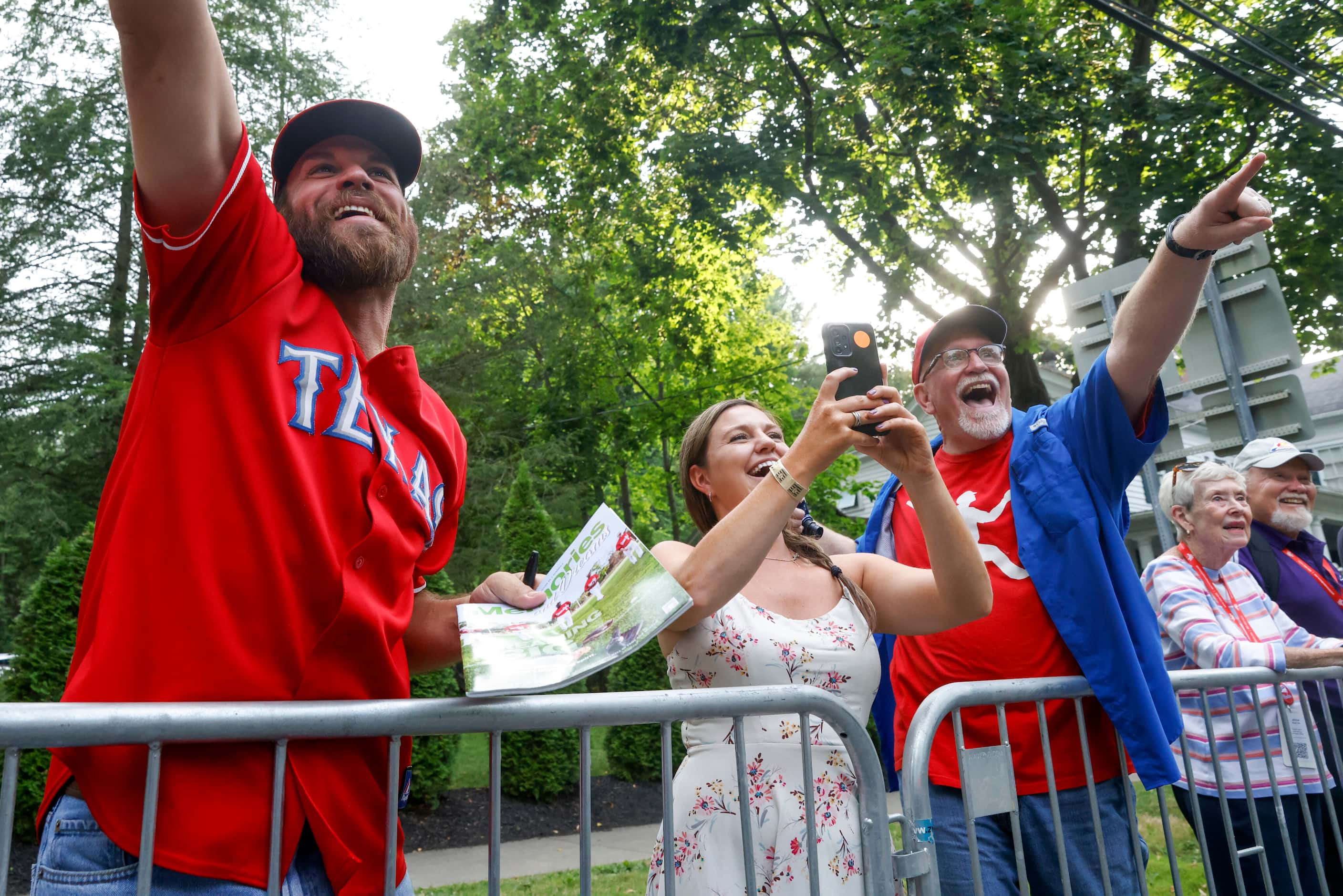 Texas Rangers fans Andrew Keith (left), Nina Dawson (center) and Rob Keith cheer for former...