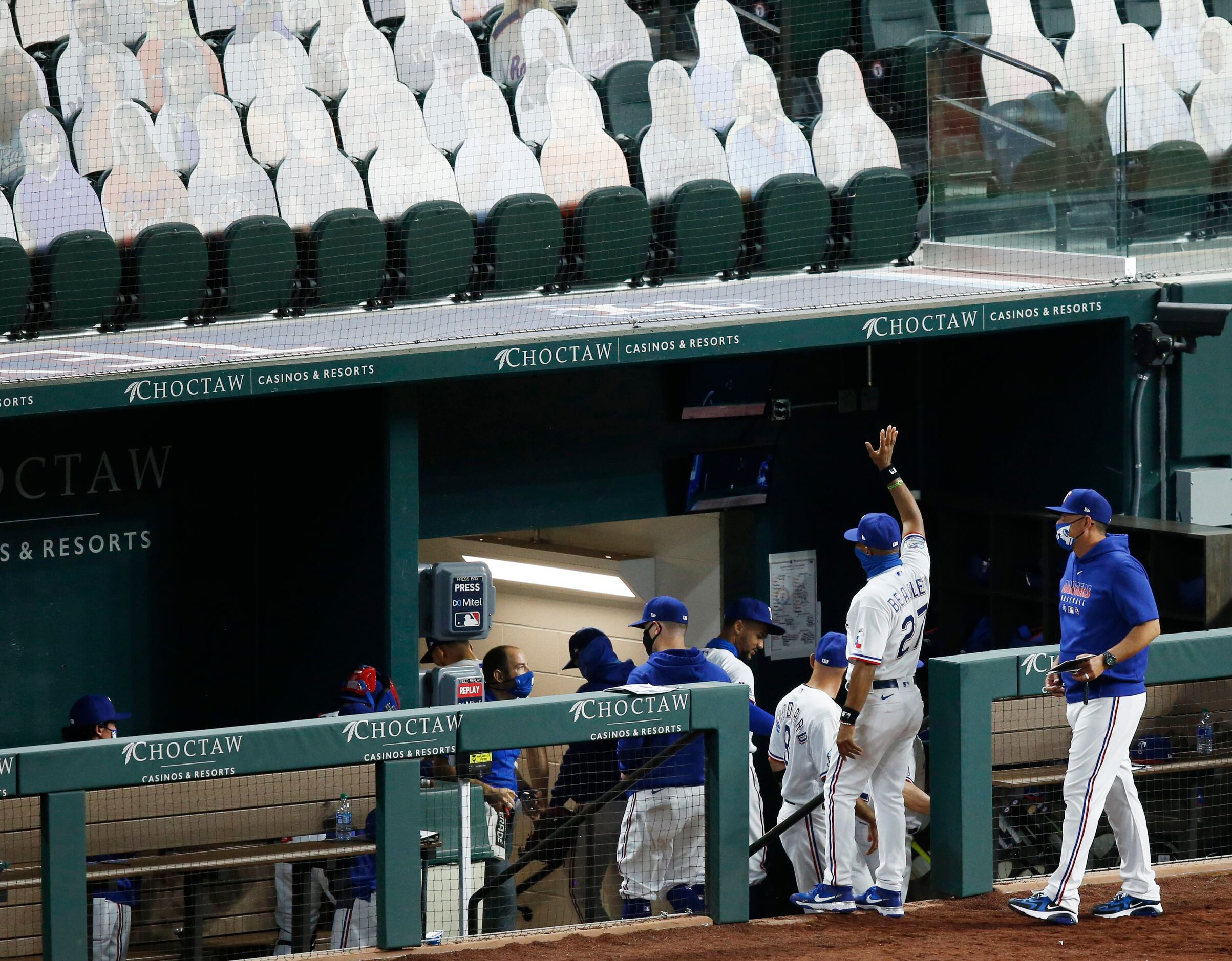 Texas Rangers third base coach Tony Beasley (27) waves towards the stands as he exits the...