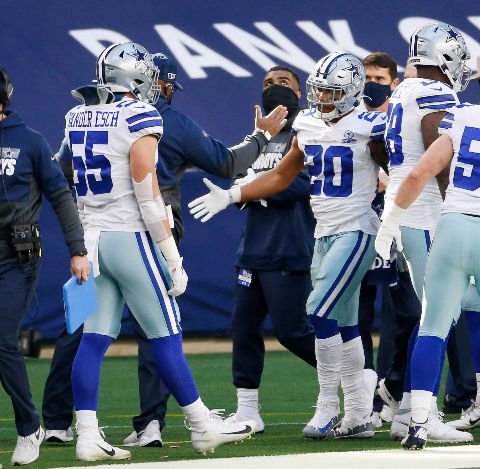 Dallas Cowboys running back Tony Pollard (20) is congratulated by teammates after scoring a...