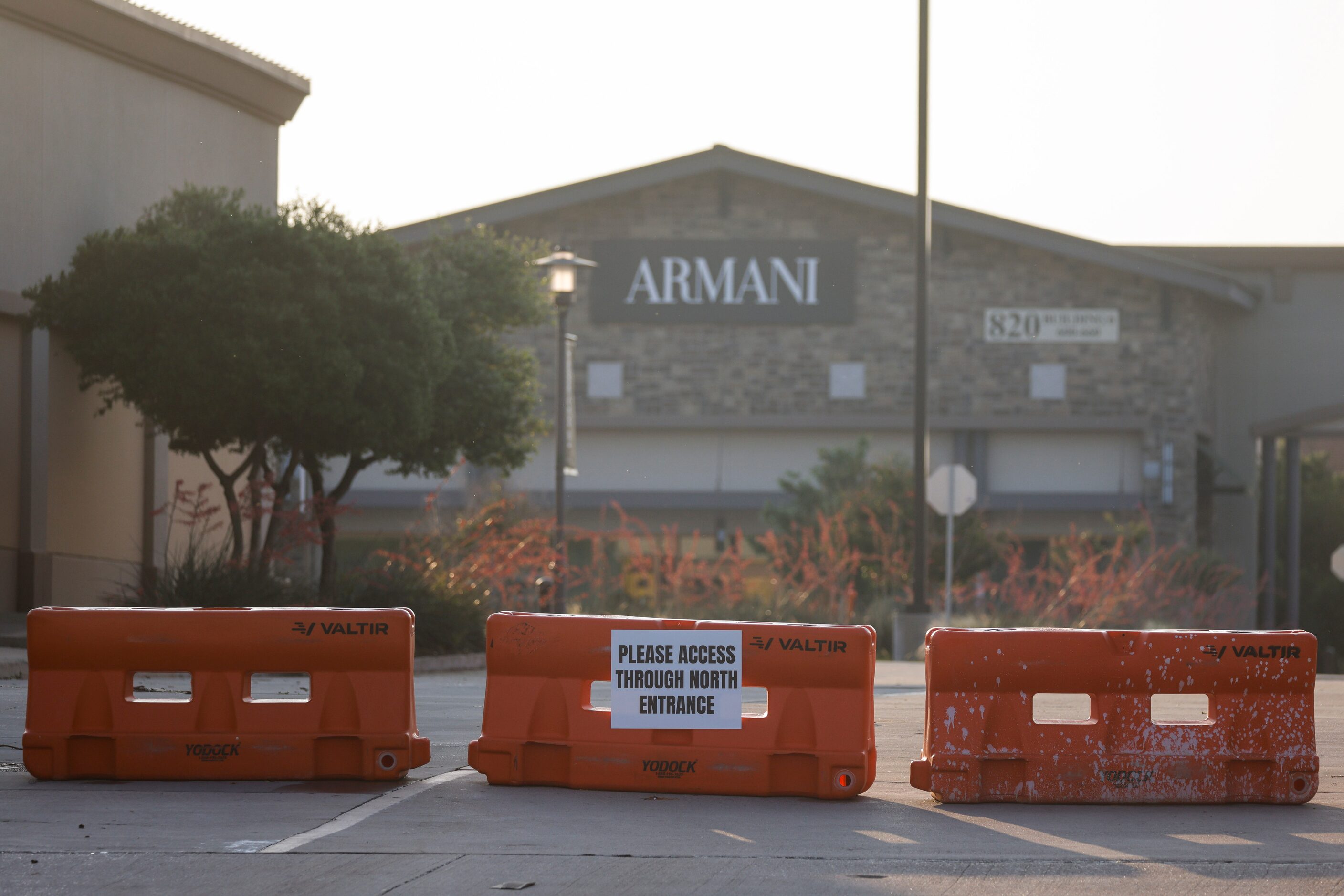 Barricades blocks one of the entrances of Allen Premium Outlets mall during the early hours...