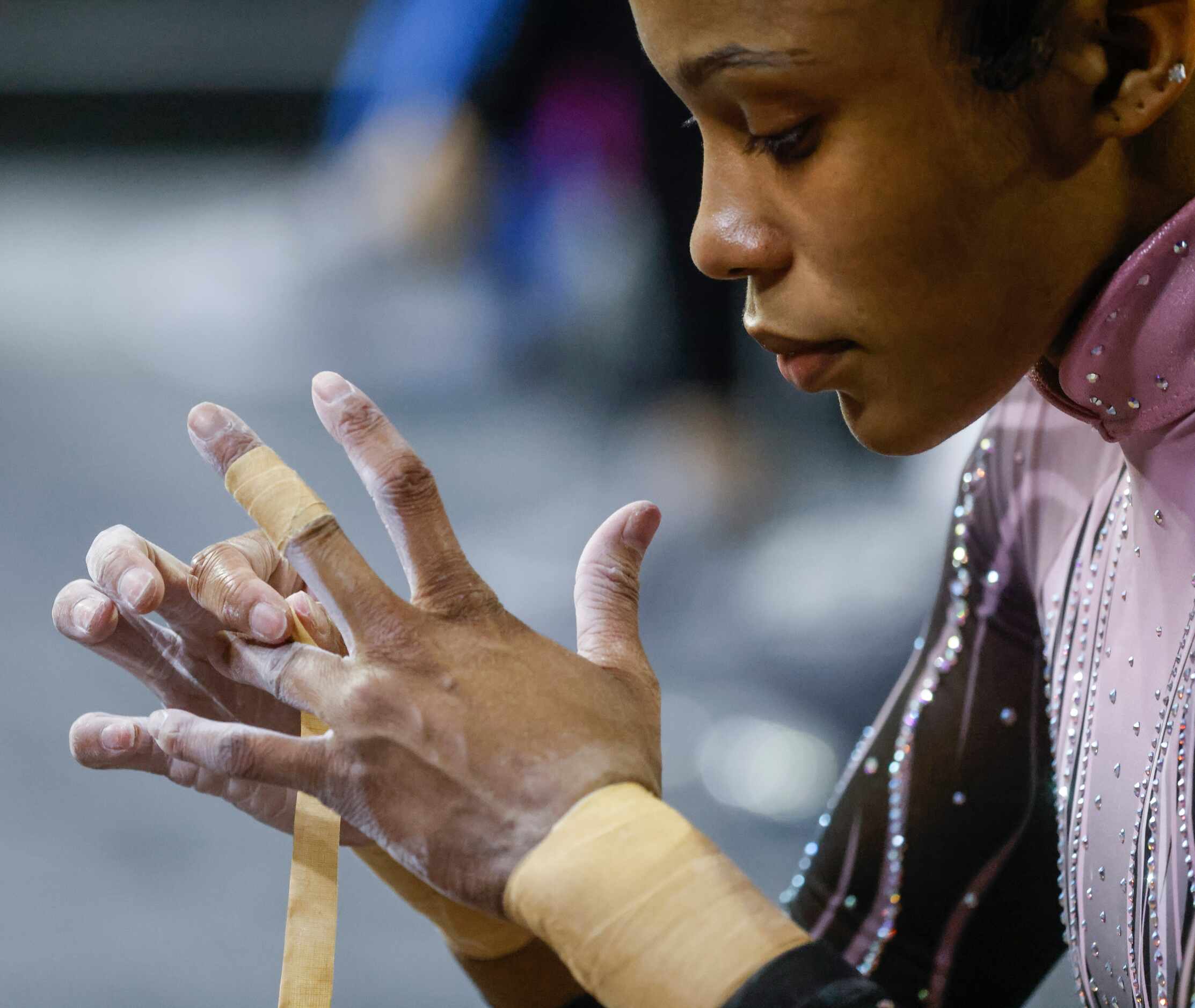 Nikki Smith of Eurostars Gymnastics, West Bloomfield, Michigan tapes her fingers ahead of...