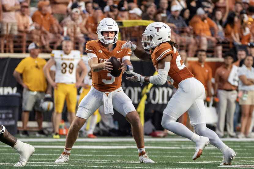 Texas quarterback Quinn Ewers hands the ball off to running back Jonathon Brooks during the...