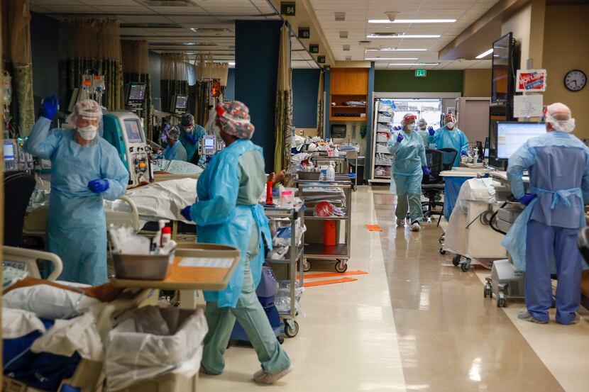 Medical workers treat critically ill patients filling bed after bed in the Parkland Hospital...