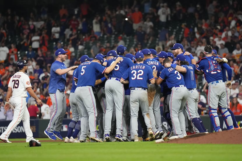 Texas Rangers celebrate by the mound as Houston Astros first baseman Jose Abreu (79) makes...