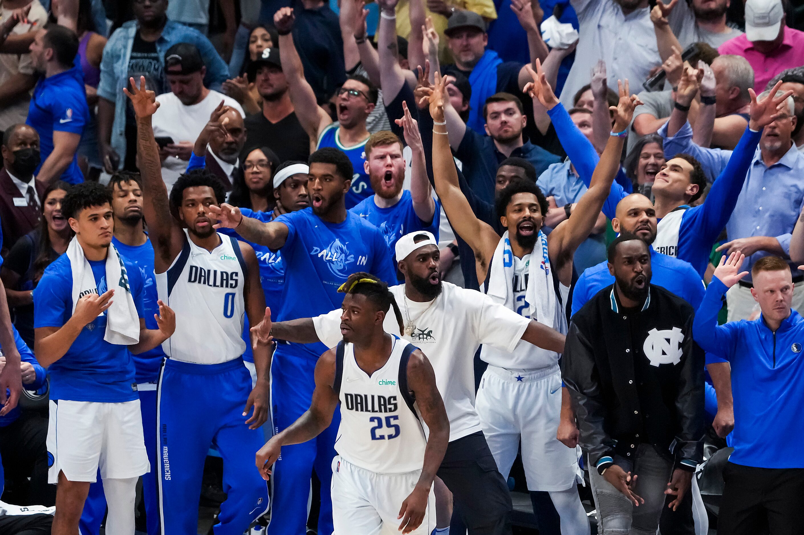 Dallas Mavericks players celebrate on the bench after forward Reggie Bullock (25) hit a...