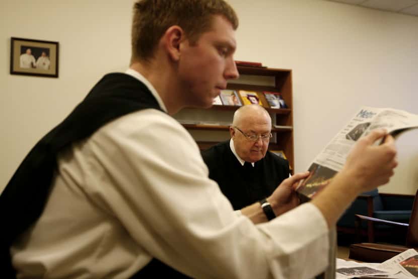 Brother Lawrence Brophy reads the newspaper with the Rev. Denis Farkasfalvy after the...