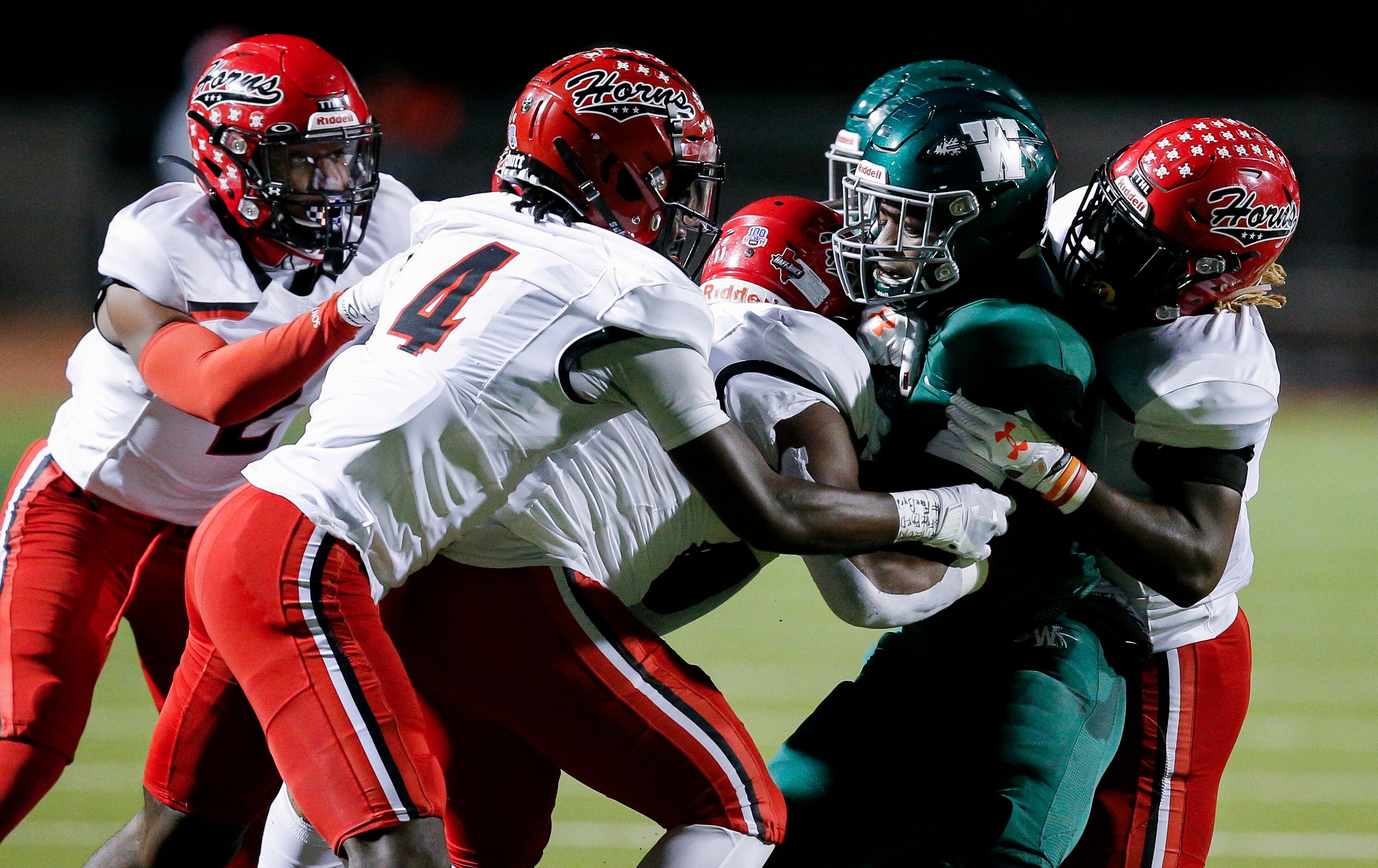 Waxahachie senior wide receiver Brandon Hawkins Jr., second from right, is tackled by...