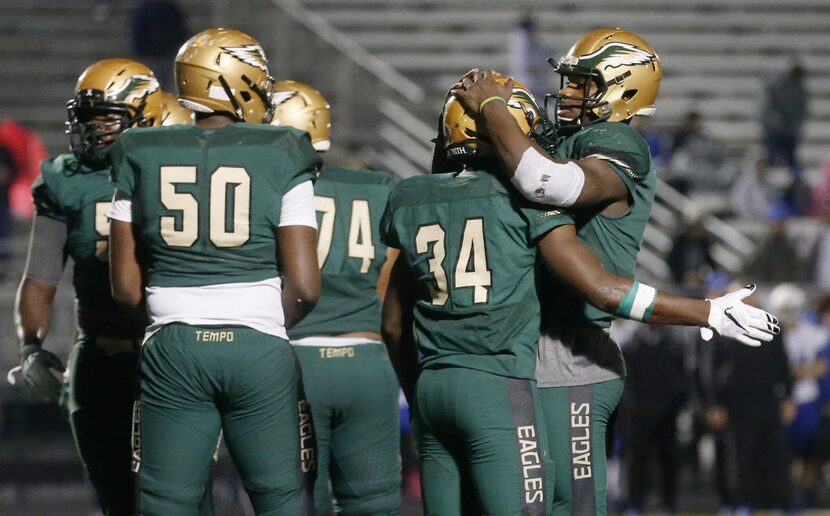 DeSoto running back Kelan Walker (34) is congratulated by quarterback Trsiten Wallace (5)...