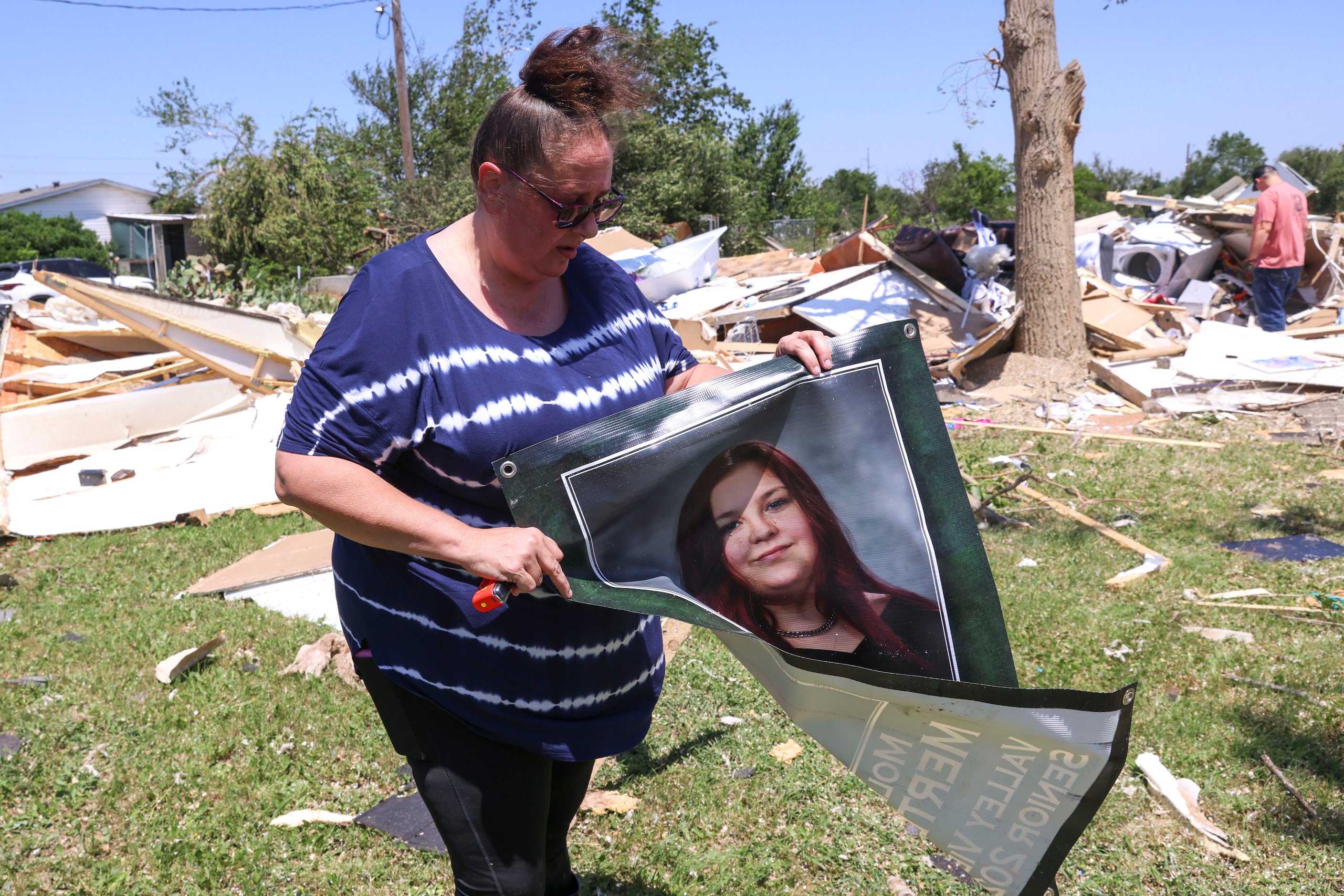 Amber Lidster, 44, resident of Valley View for 40 years, folds the senior year photo of her...