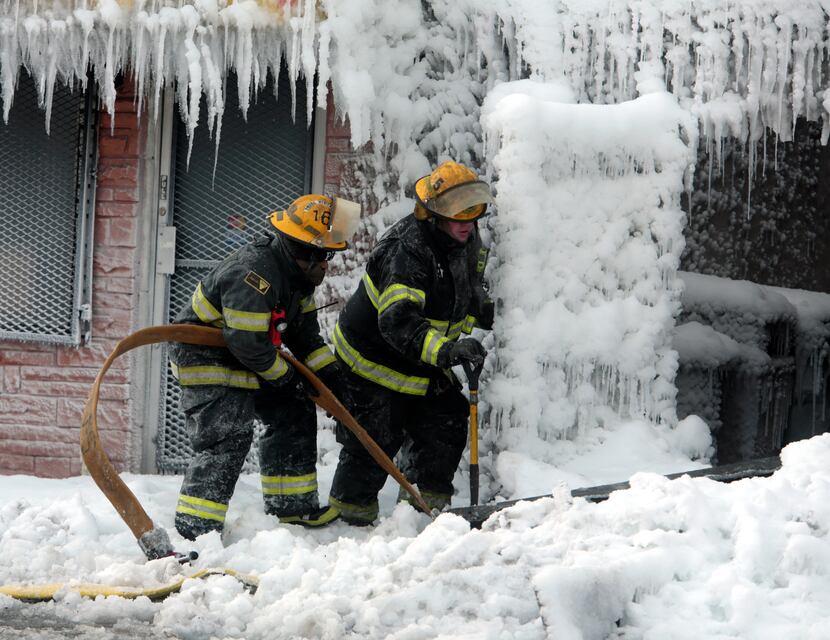 Philadelphia firefighters work to free equipment at the scene of an overnight blaze in west...
