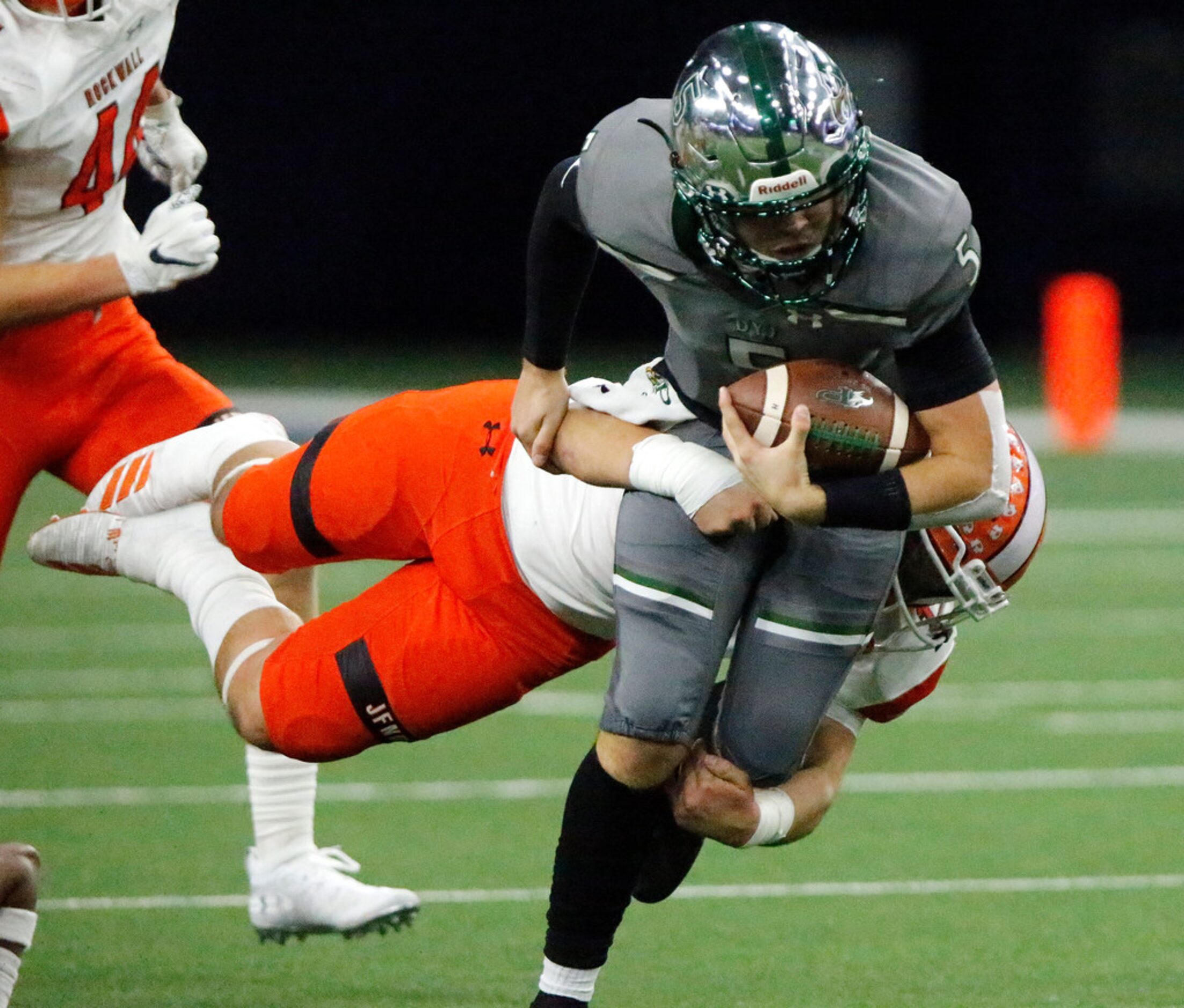 Prosper High School quarterback Jackson Bailey (5) is tackled by Rockwall High School...