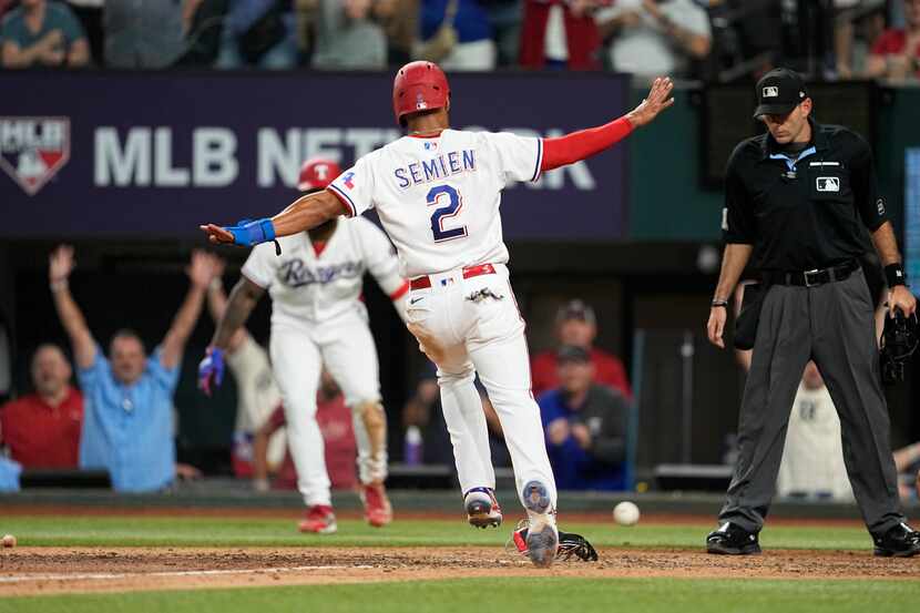 Texas Rangers' Marcus Semien(2) scores on a Nathaniel Lowe single ahead of the throw to the...