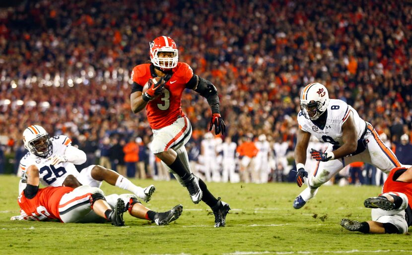 Georgia running back Todd Gurley (3) runs between Auburn linebacker Justin Garrett (26) and...