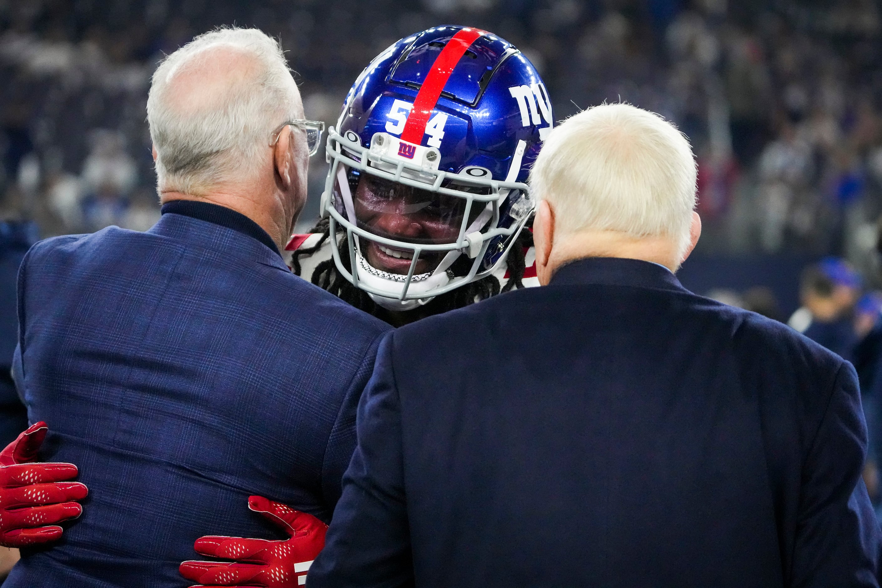 New York Giants linebacker Jaylon Smith (54) hugs Dallas Cowboys executive vice president...