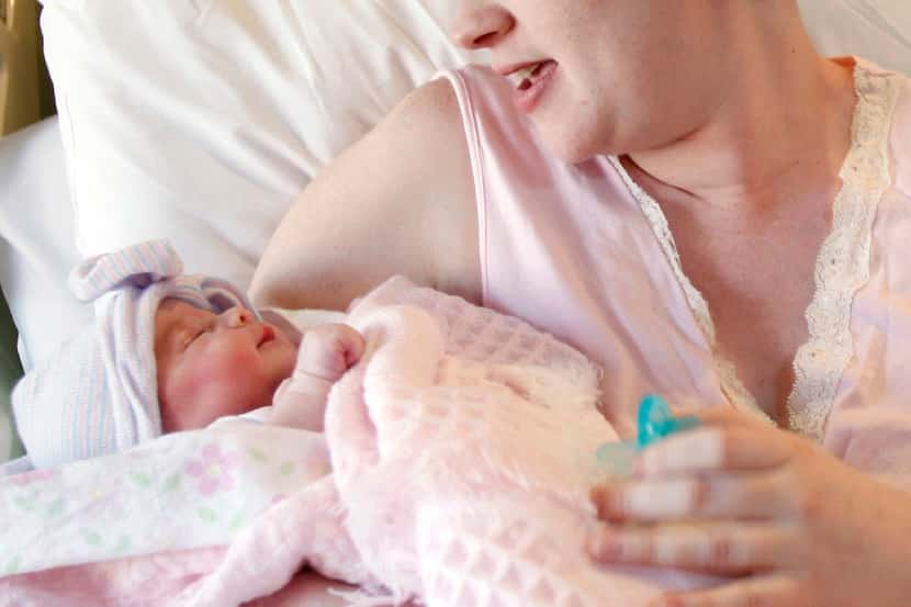 FILE - In this file photo, a mother holds her newborn baby at a hospital in Corpus Christi,...