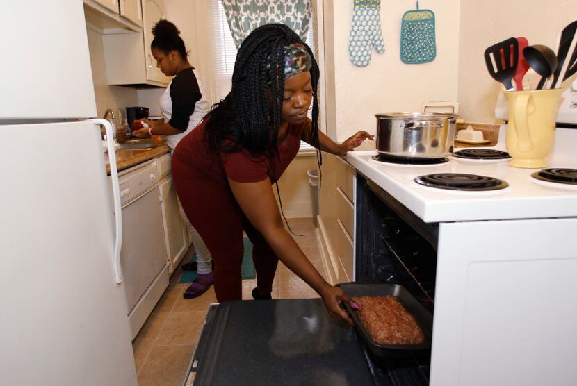 Ebony Green, right, prepares meatloaf with her daughter Amaris Dobbins, 13, in their...