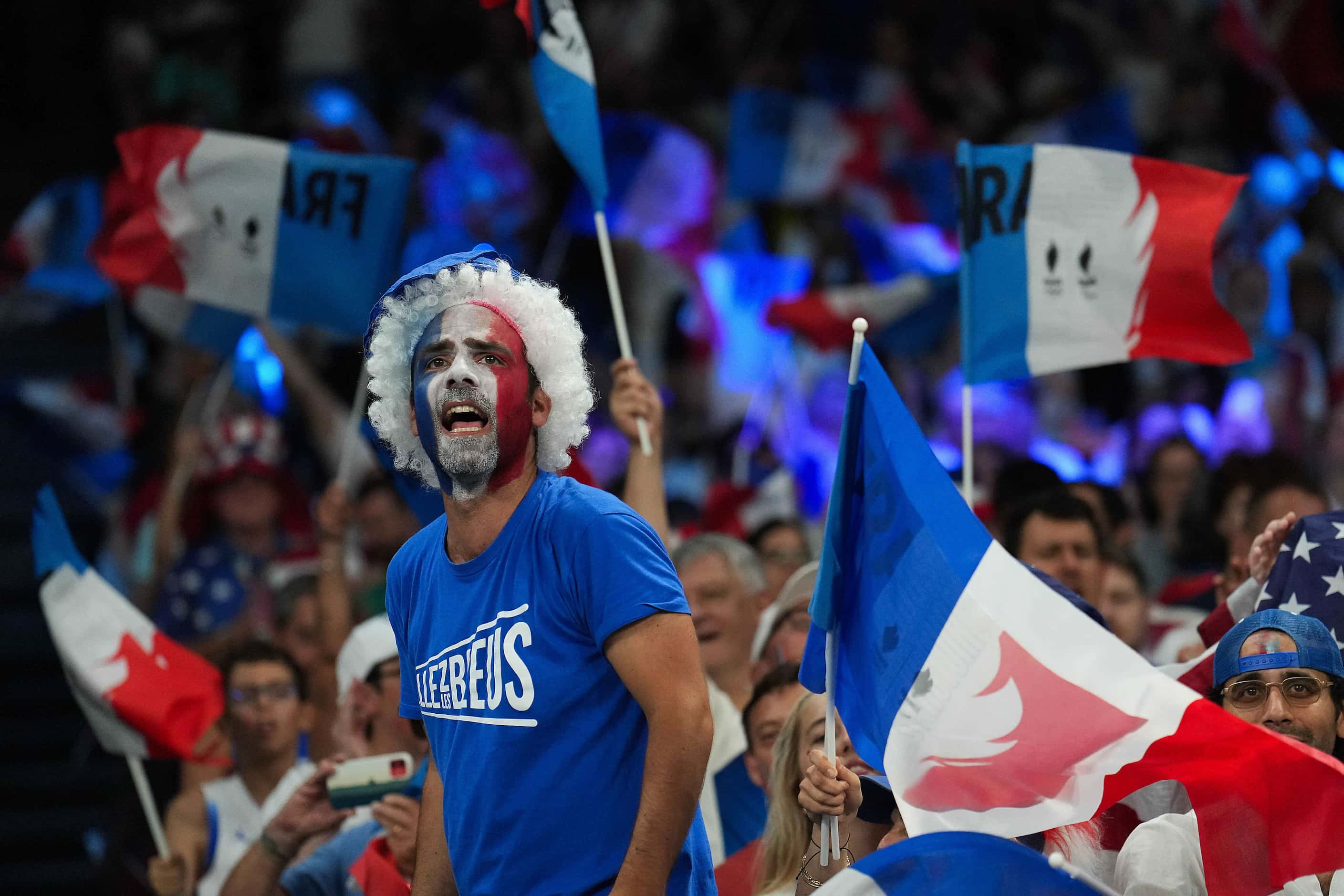 Fans cheer for France during the first half of the women’s gold medal basketball game...