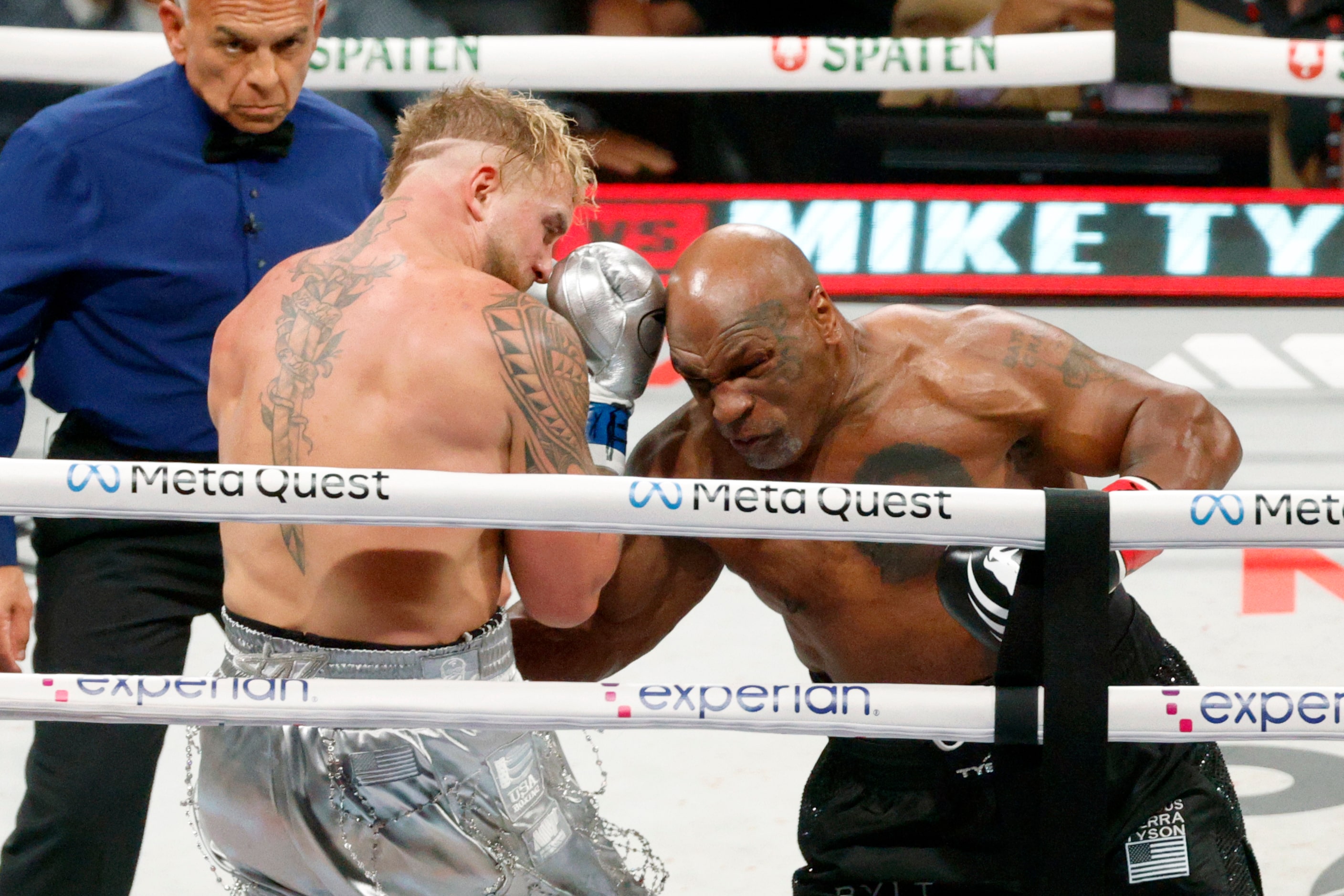 Mike Tyson delivers a body blow to Jake Paul during the first round of a heavyweight boxing...