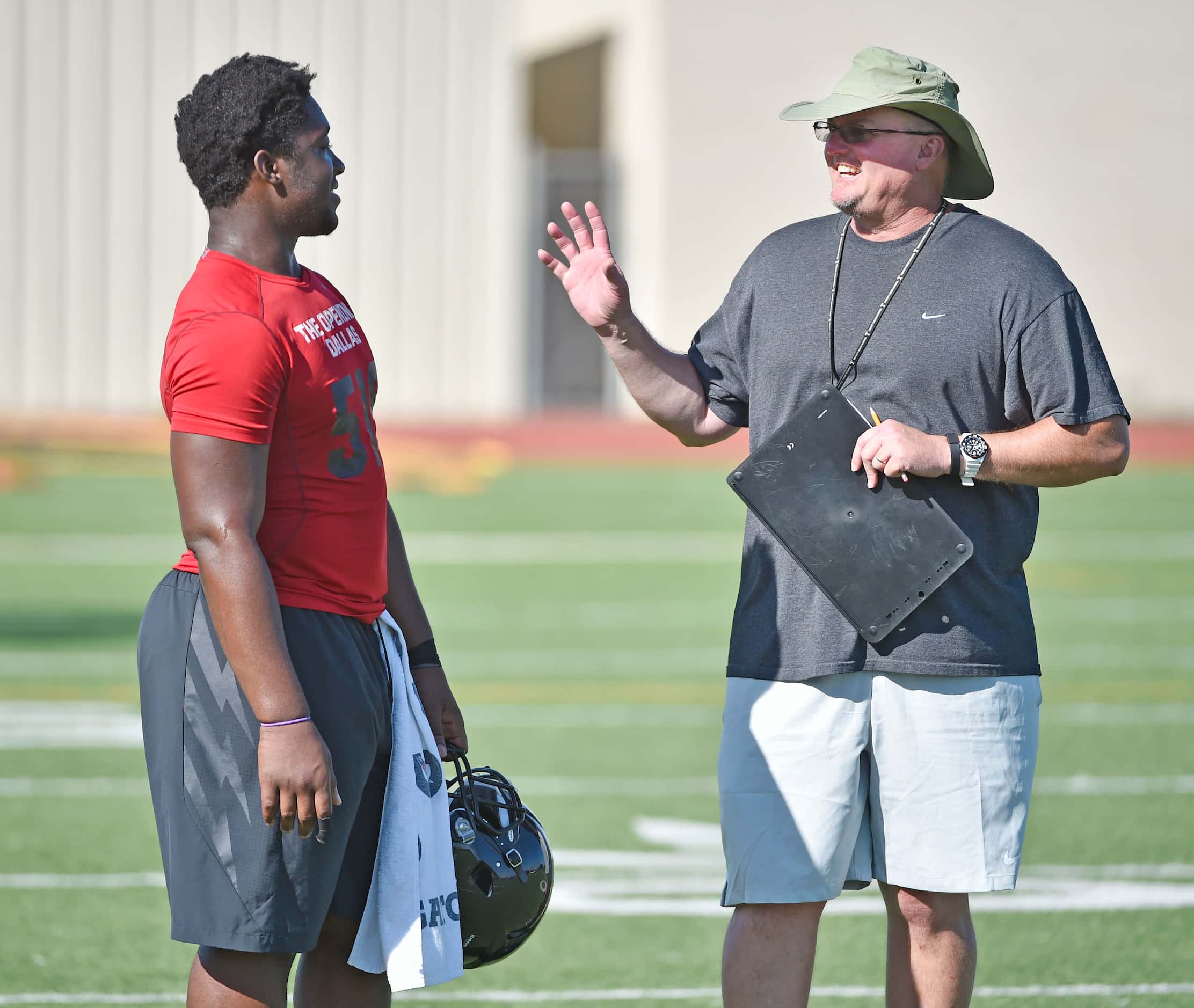 Quarterback Tyler Natee listens to coach Chris Jensen during Euless Trinity's first day of...