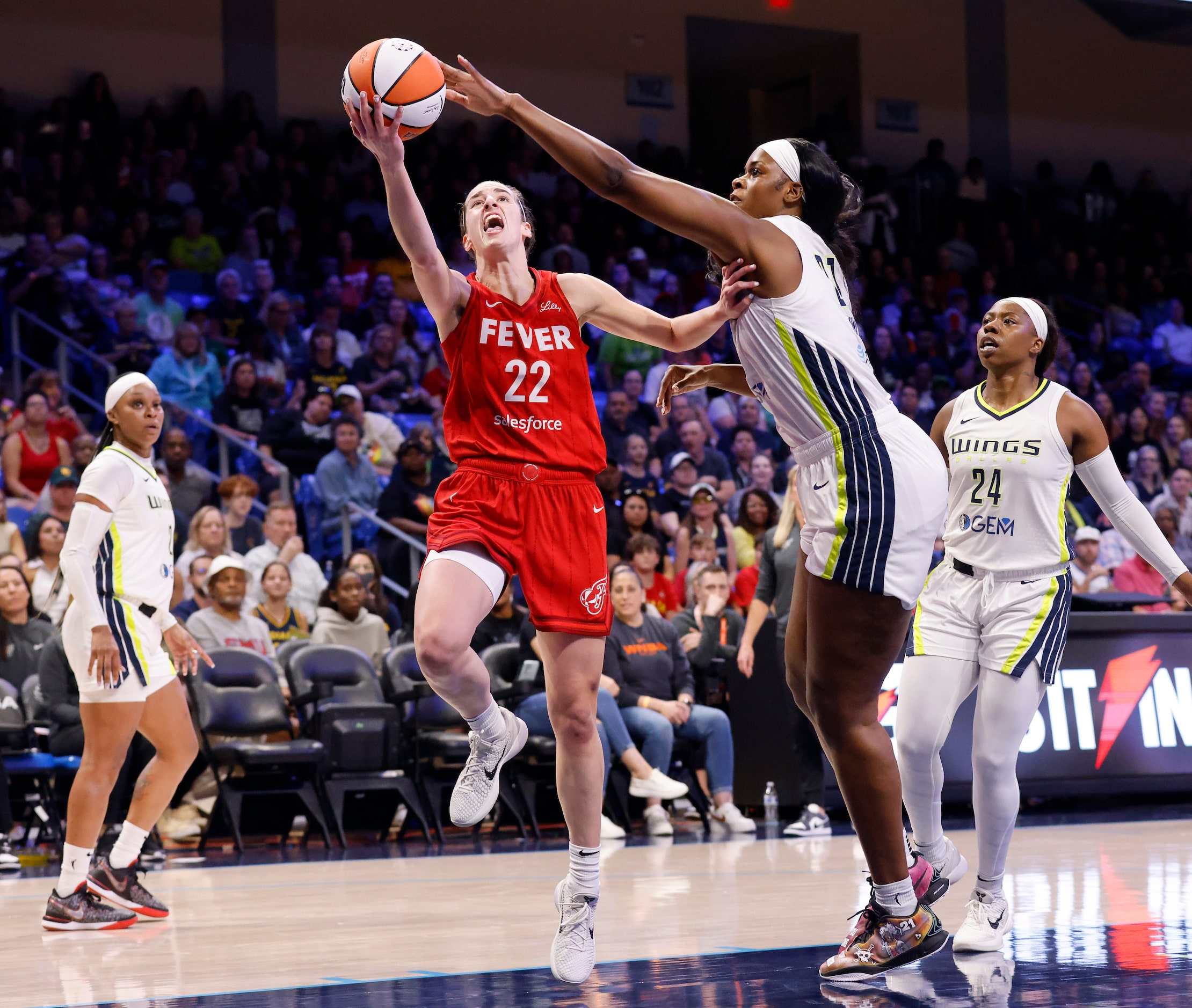 Indiana Fever guard Caitlin Clark (22) lays up a shot around Dallas Wings center Kalani...