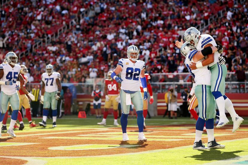 Dallas Cowboys quarterback Dak Prescott (4) celebrates with offensive guard Zack Martin (70)...
