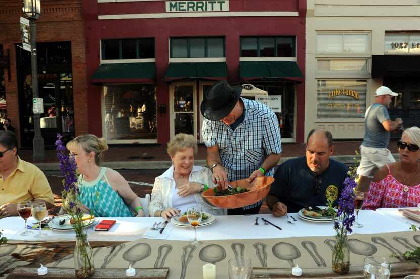 Carl Gamble serves salad to friend Lynn Scott at Night Out on 15th Street in downtown Plano,...
