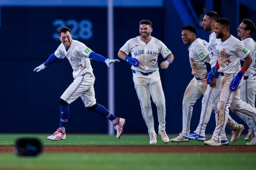 Toronto Blue Jays' Ernie Clement, left, celebrates after his walkoff RBI single in the ninth...