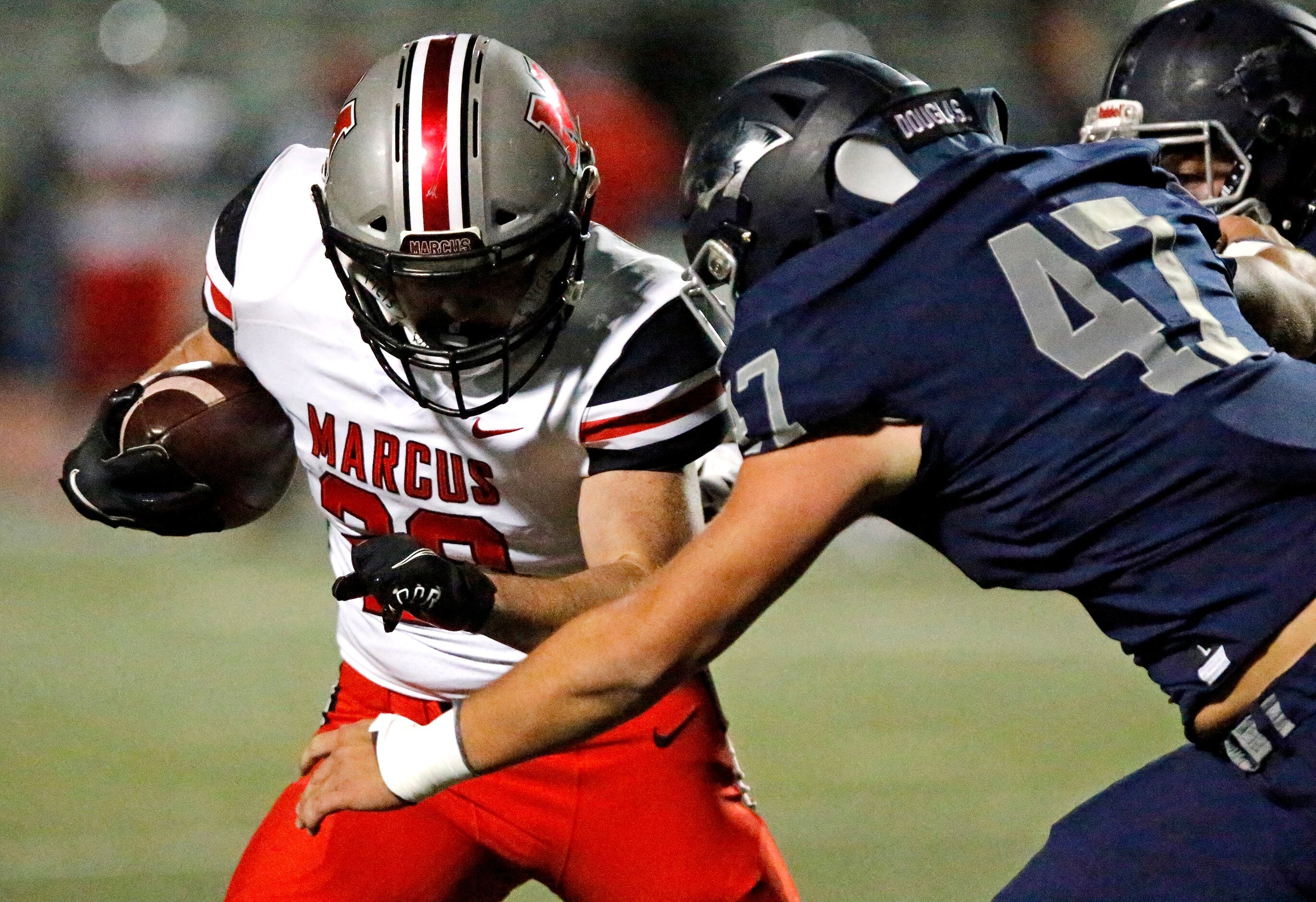 Flower Mound Marcus running back Walker Wells (20) is met by Flower Mound High School...