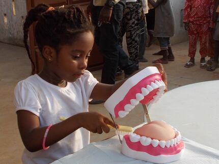 Eno Boateng of Ghana practices brushing teeth on a dental model in Elizabeth...