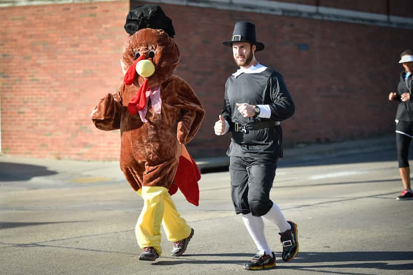 Runners dress up as a pilgrim and a turkey during the Second annual Downtown Denton Turkey...