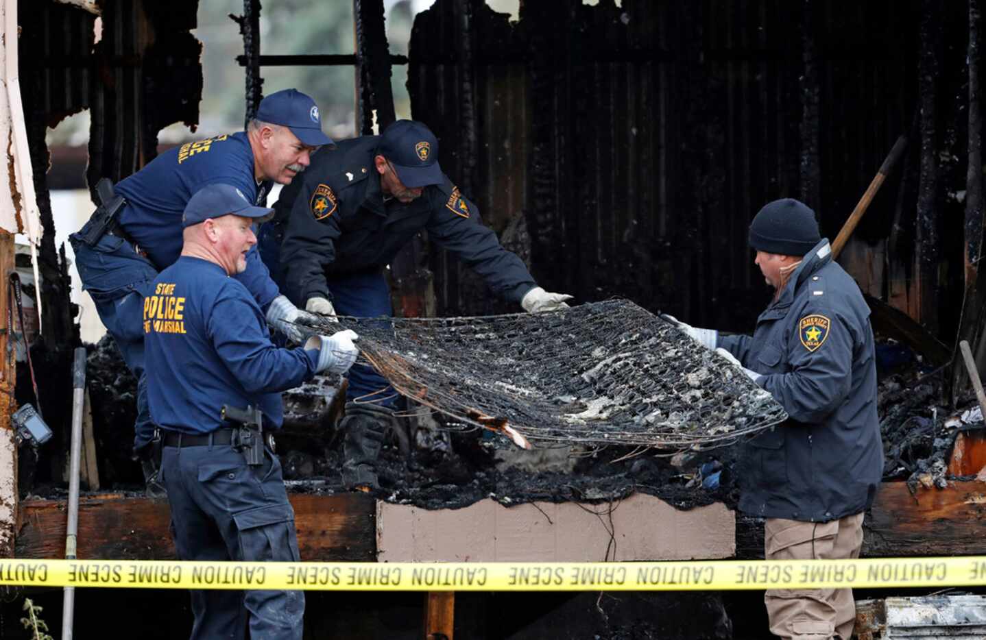 Fire marshals move debris while investigating the cause of a deadly fire Nov. 8, 2018, near...