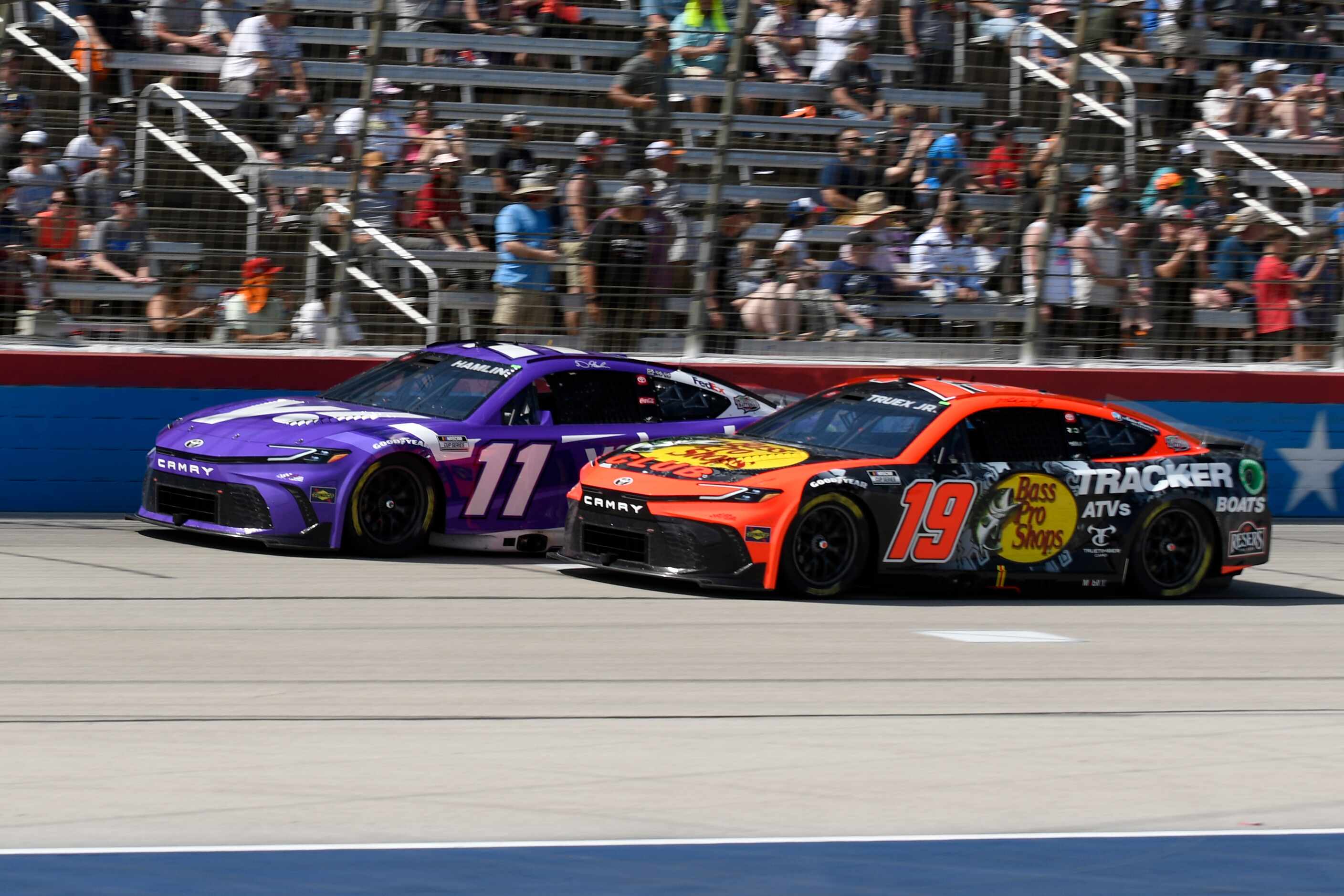 Denny Hamlin (11) and Martin Truex Jr. (19) race out of Turn 4 during the NASCAR Cup Series...