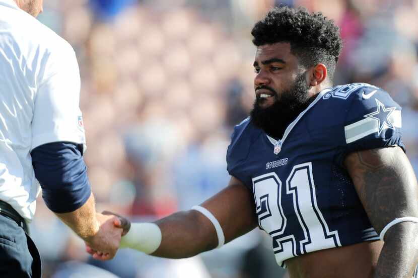 Dallas Cowboys running back Ezekiel Elliott (21) shakes hands with a staff member prior to a...