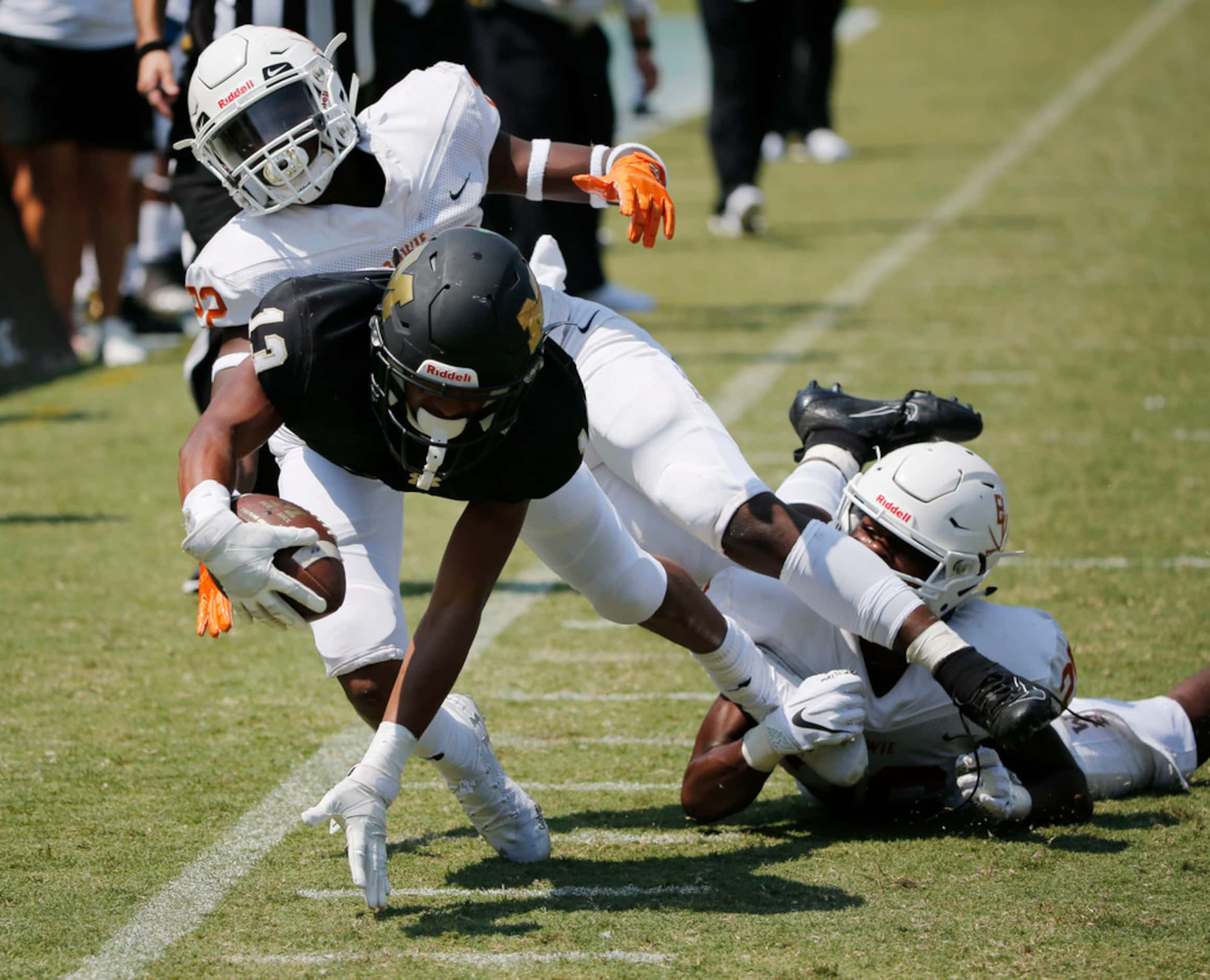 Arlington Bowie's Tre Martin (22),left, and Roderick Hudson (26) tackle Mansfield's David...