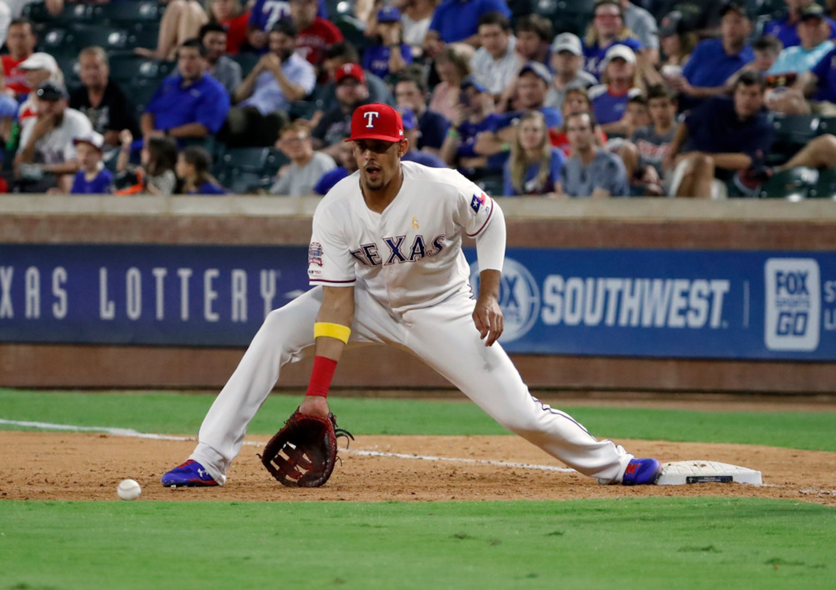 Texas Rangers' Ronald Guzman reaches down for the throw to first on a ground out by Oakland...